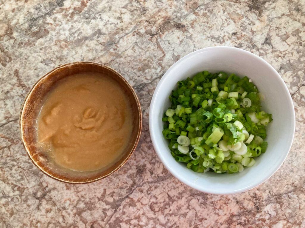 miso and sake mix in a brown bowl on the left, minced scallions in a white bowl on the left