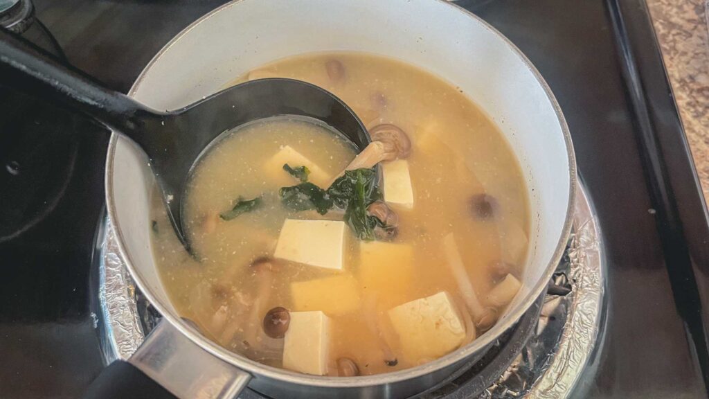 miso soup and a black ladle in a pot.