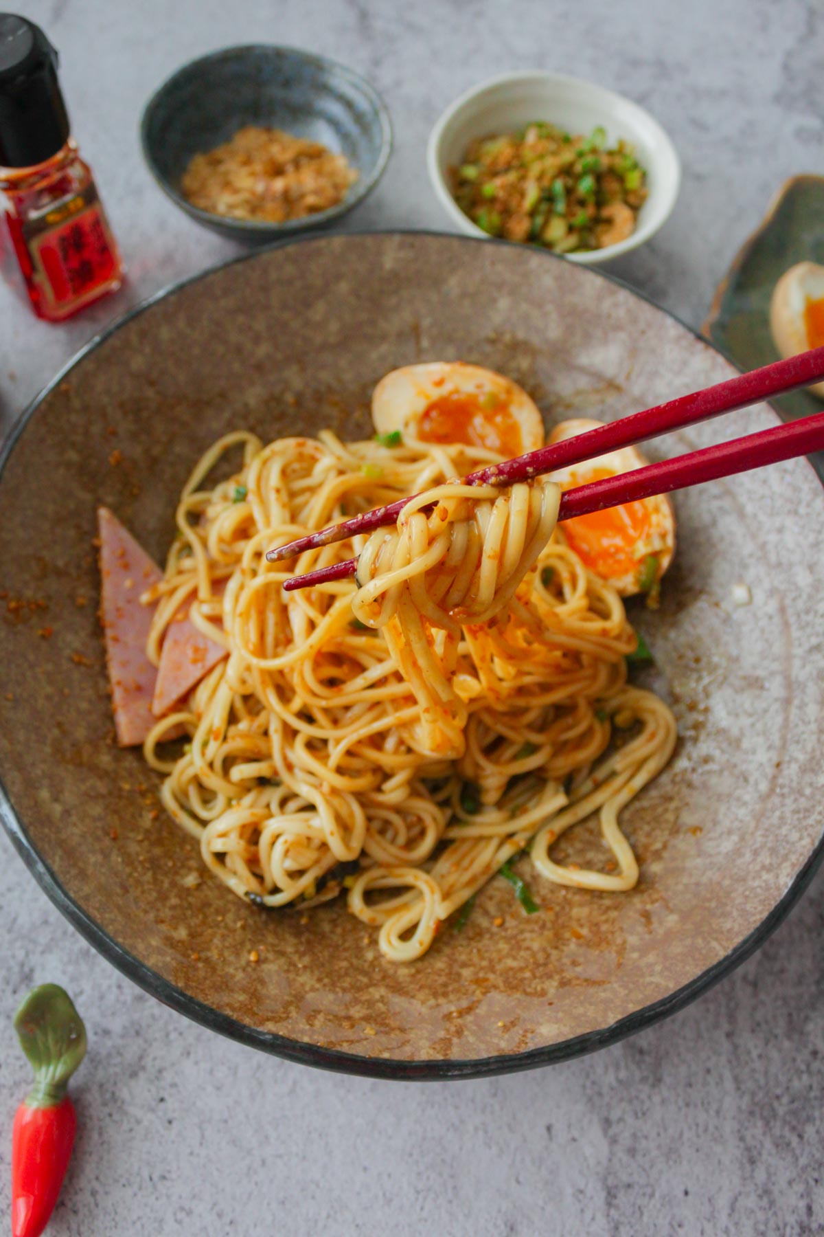 chopsticks are holding the abura soba noodles that are mixed with the sauce