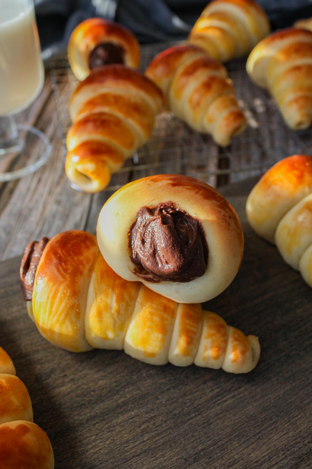 four chocolate coronets on a wood board, more behind