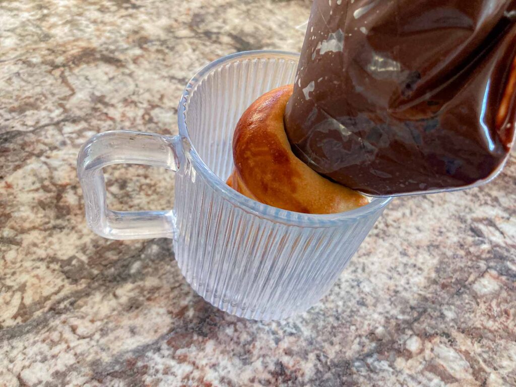 a coronet is being filled with chocolate custard