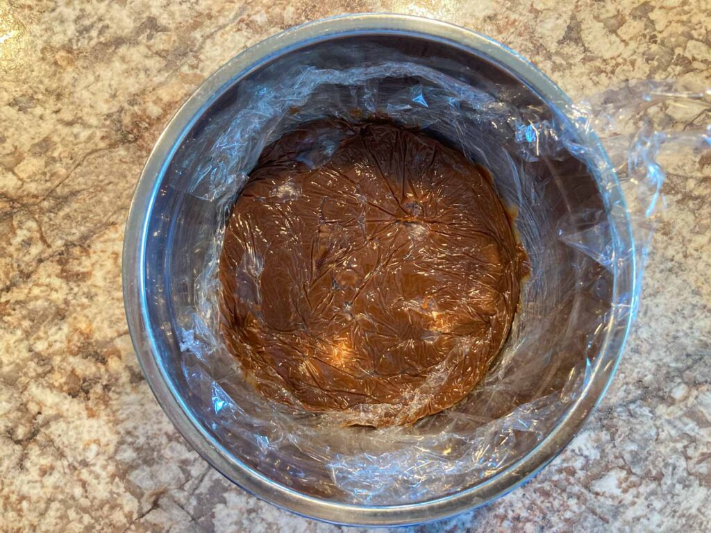 chocolate custard covered with plastic wrap in a bowl