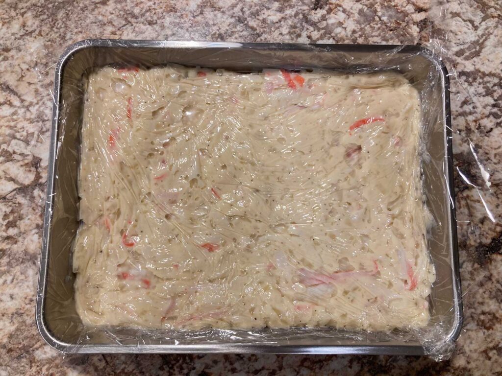 white sauce for creamy crab croquette in a food tray covered with plastic wrap