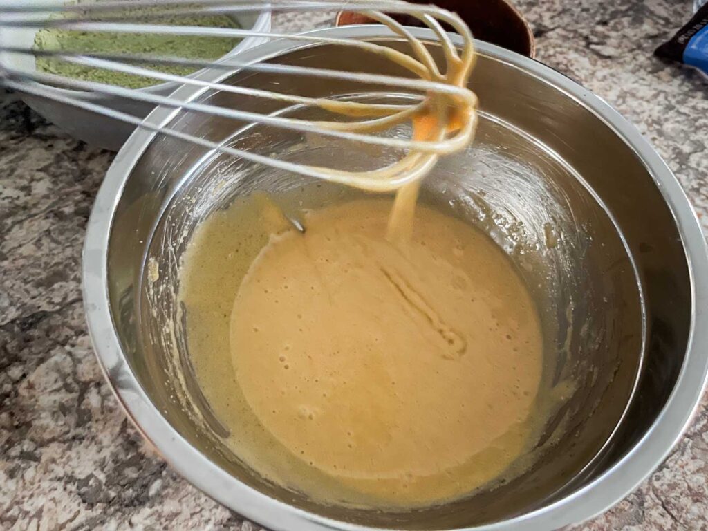 browned butter and sugar and eggs in a bowl for matcha chocolate chip cookies