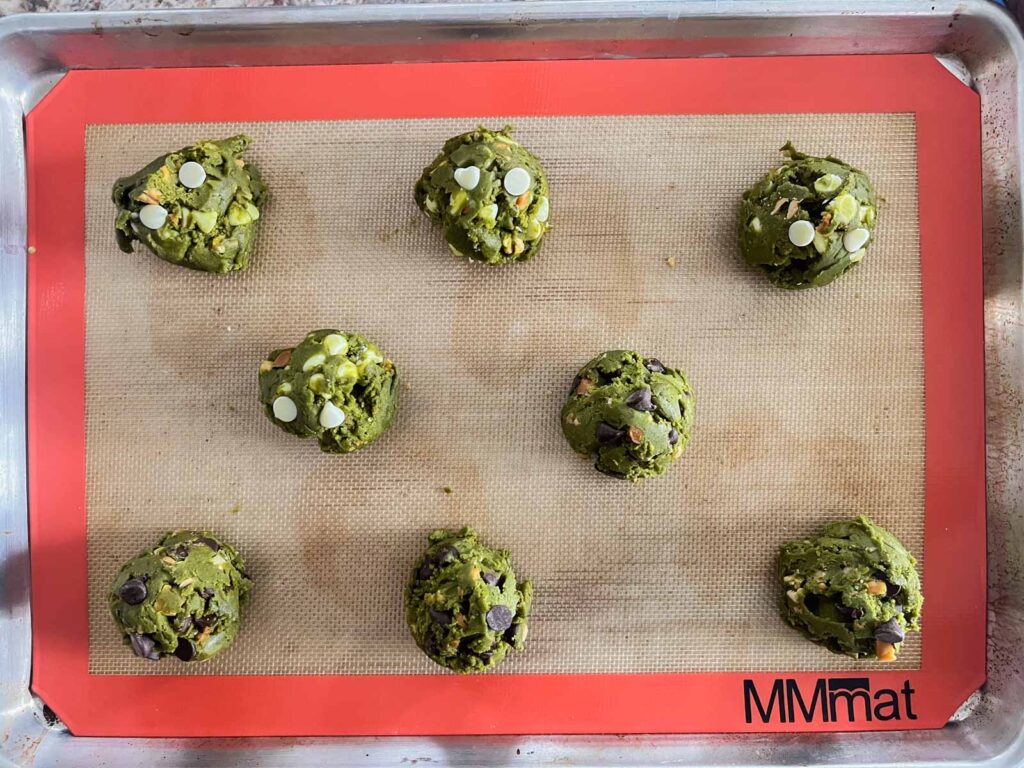 matcha chocolate chip cookie dough balls on a baking sheet