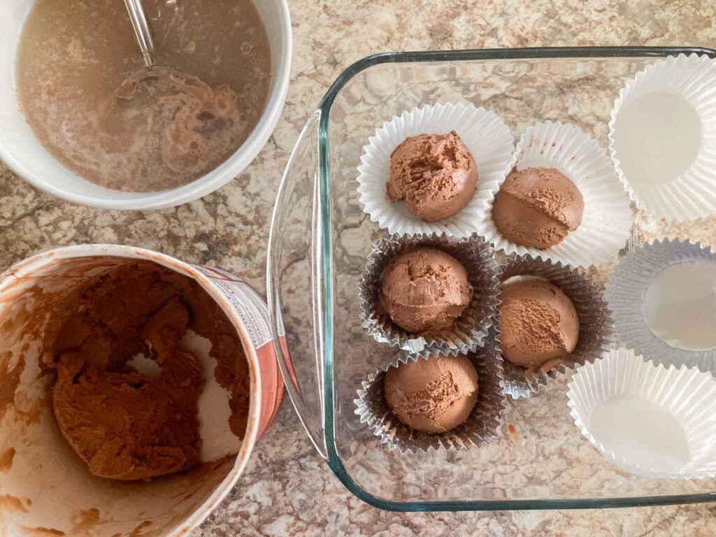 chocolate ice cream is scooped and placed to muffin cups