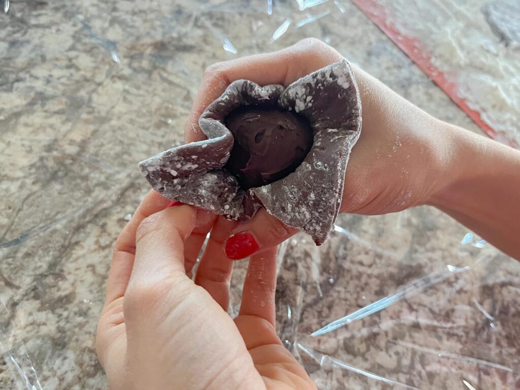 a ball of ganache is wrapped in chocolate mochi