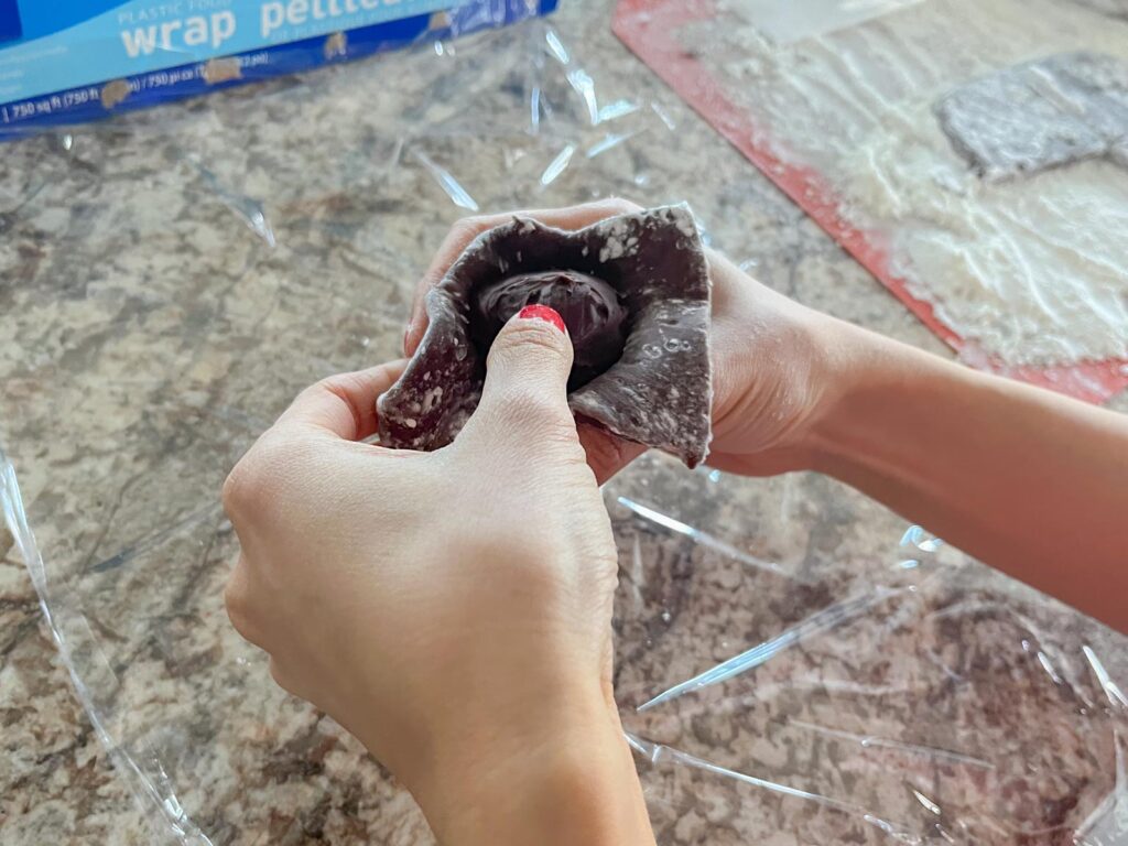 a ball of ganache is wrapped in chocolate mochi