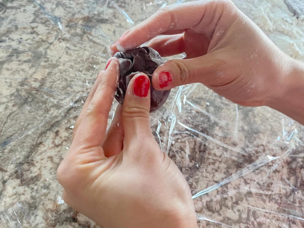 a ball of ganache is wrapped in chocolate mochi