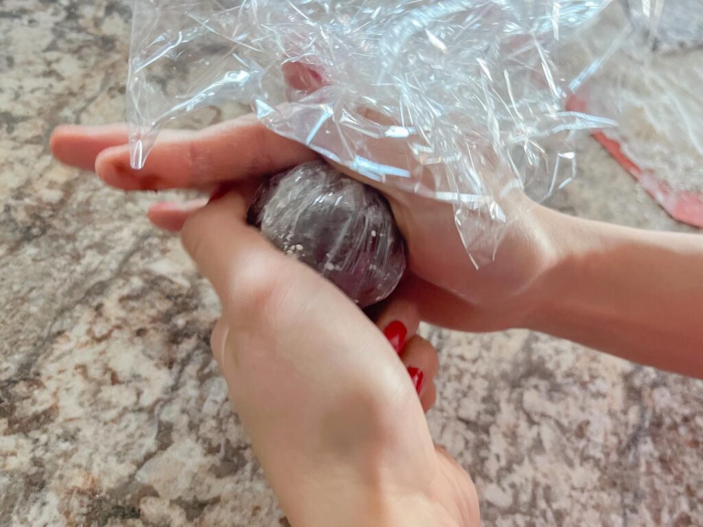 a chocolate mochi is wrapped in plastic wrap