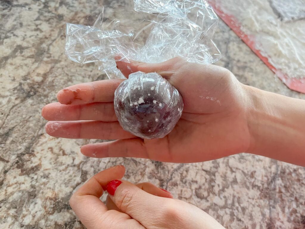 a chocolate mochi wrapped in plastic wrap