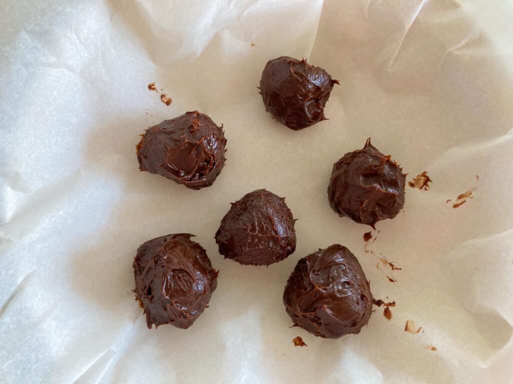 six chocolate ganache balls on parchment paper