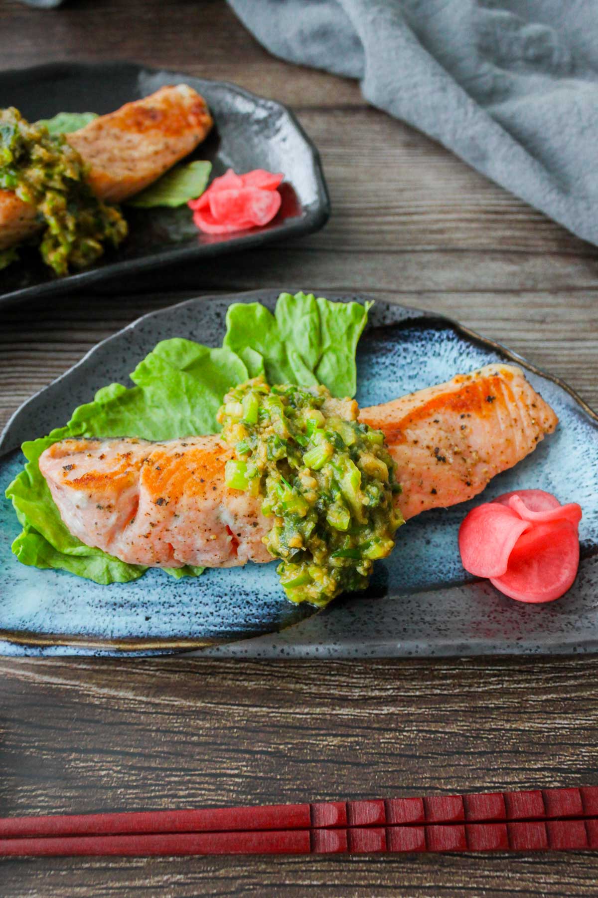 Salmon with miso butter scallion sauce on a plate.