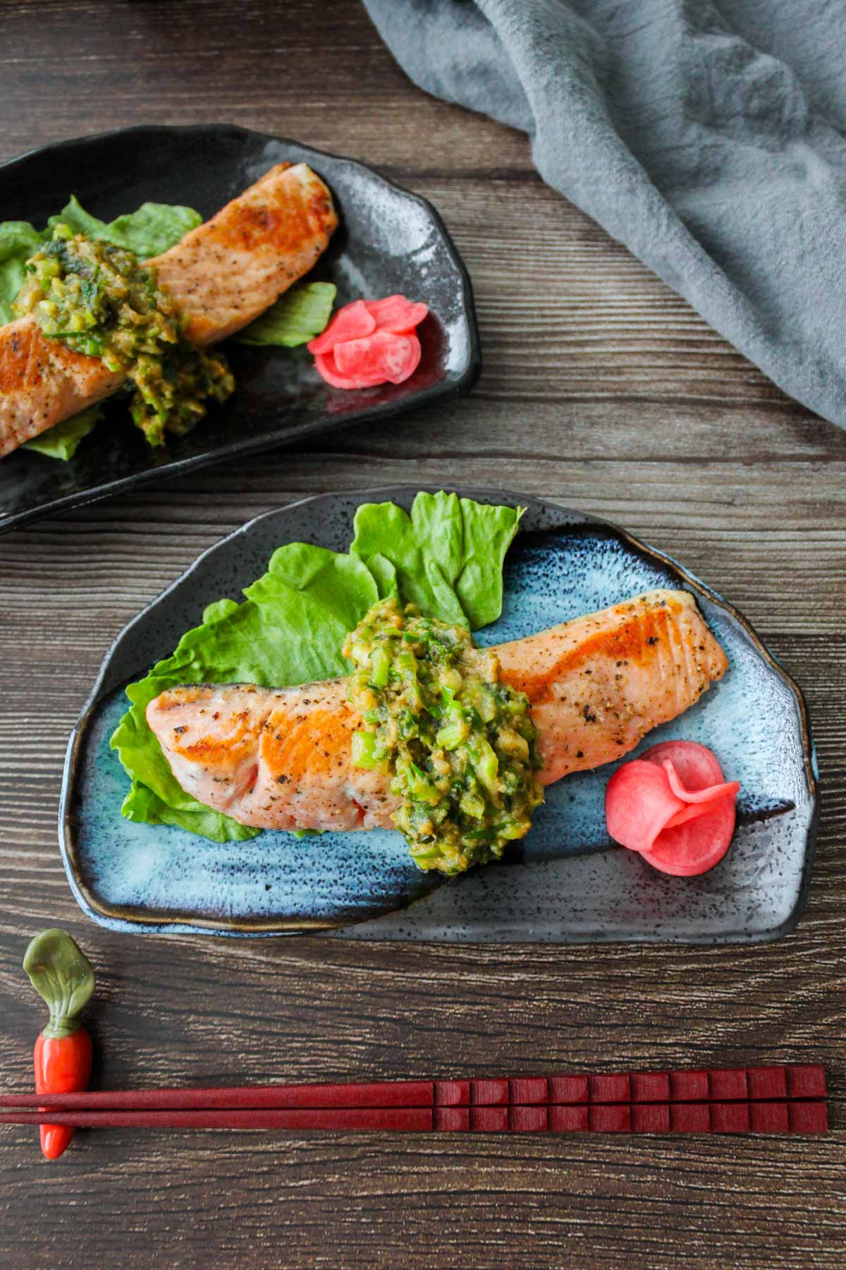 Salmon with miso butter scallion sauce on a plate.