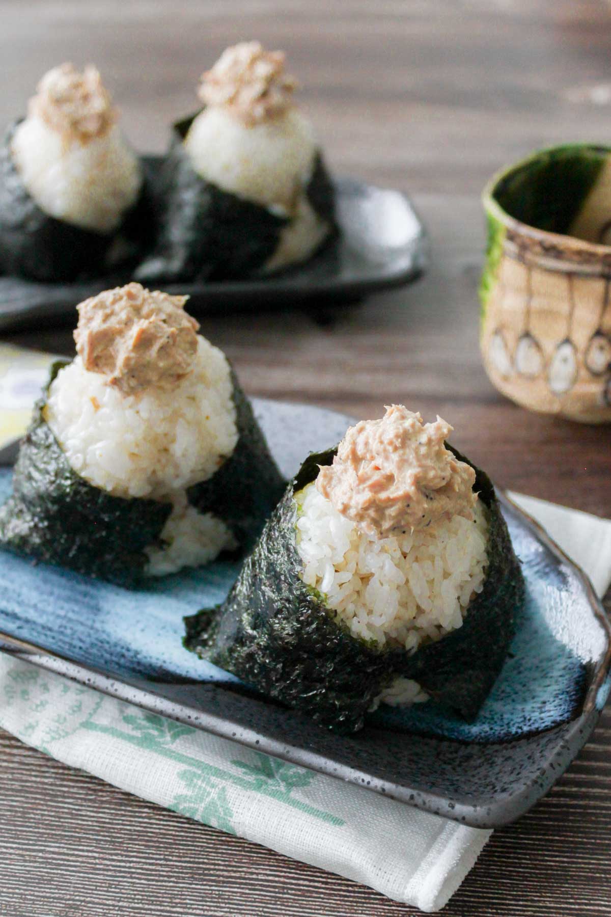 Two tuna mayo onigiri on a plate.