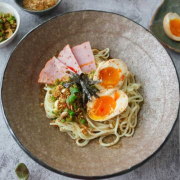 Abura soba topped with ajitama, ham, seaweed, and sesame and scallion mix.