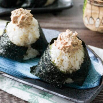 Two tuna mayo onigiri on a plate.