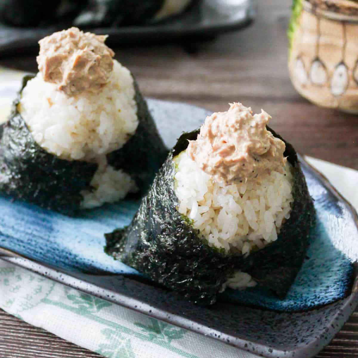 Two tuna mayo onigiri on a plate.