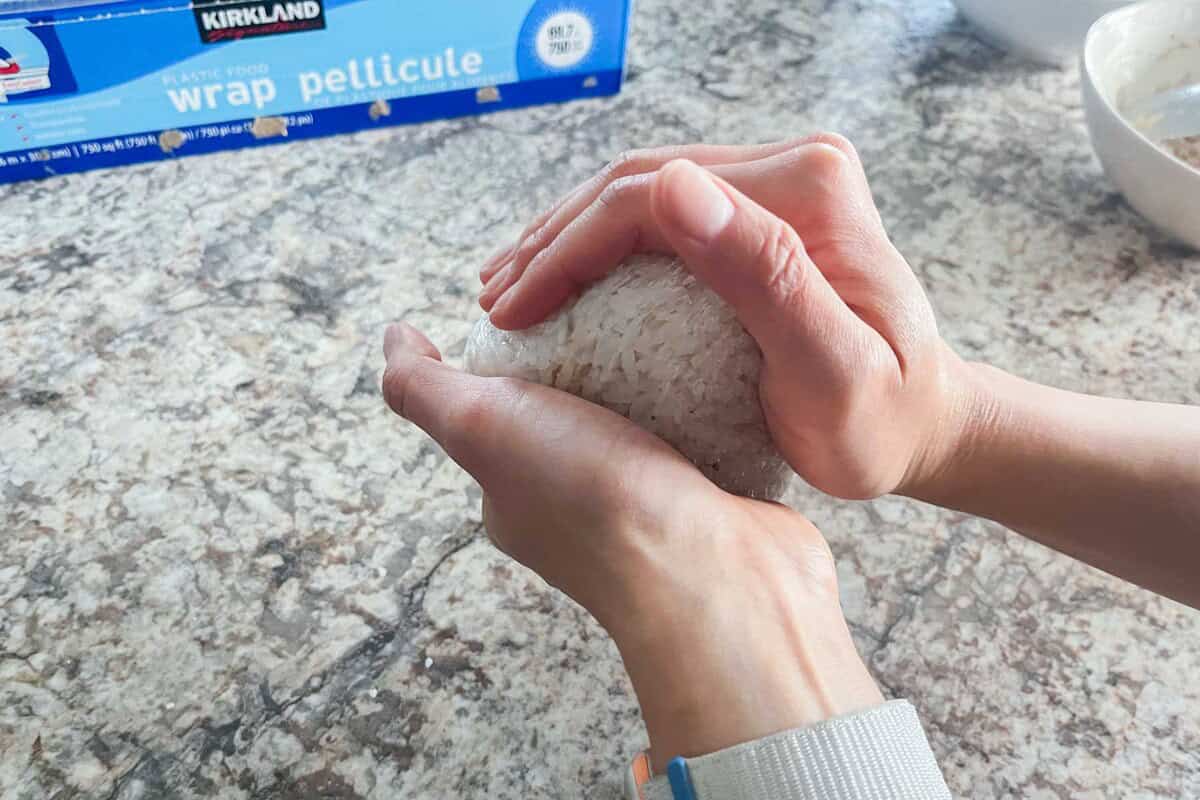 Making onigiri triangle with two hands.