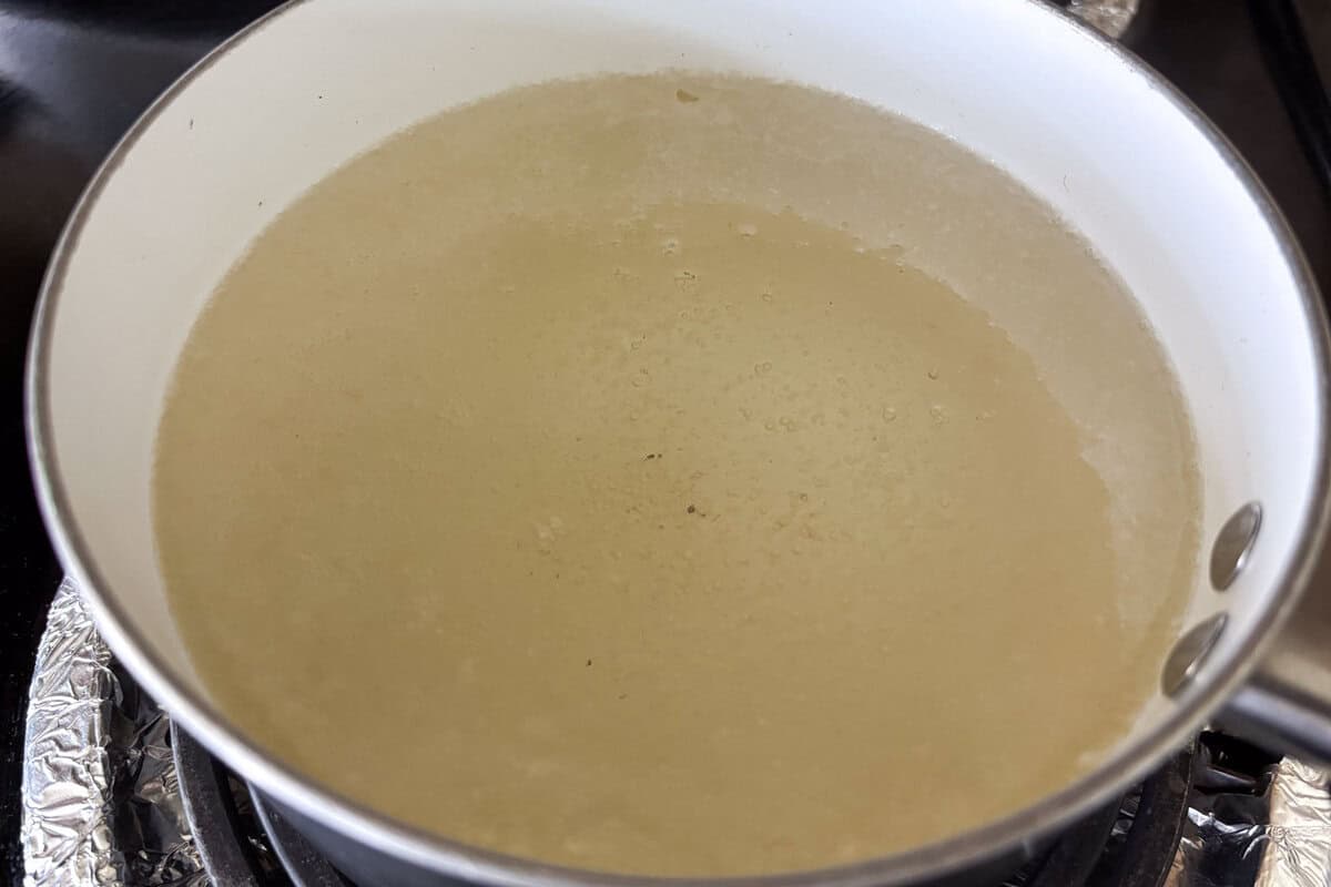 small bobbles are floating from the bottom of the pot.