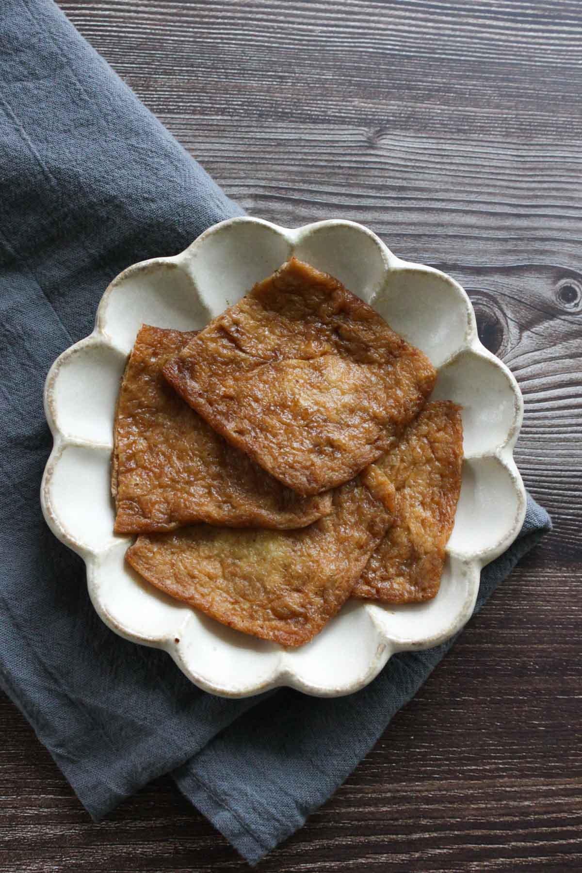 Four inari age on a white plate.