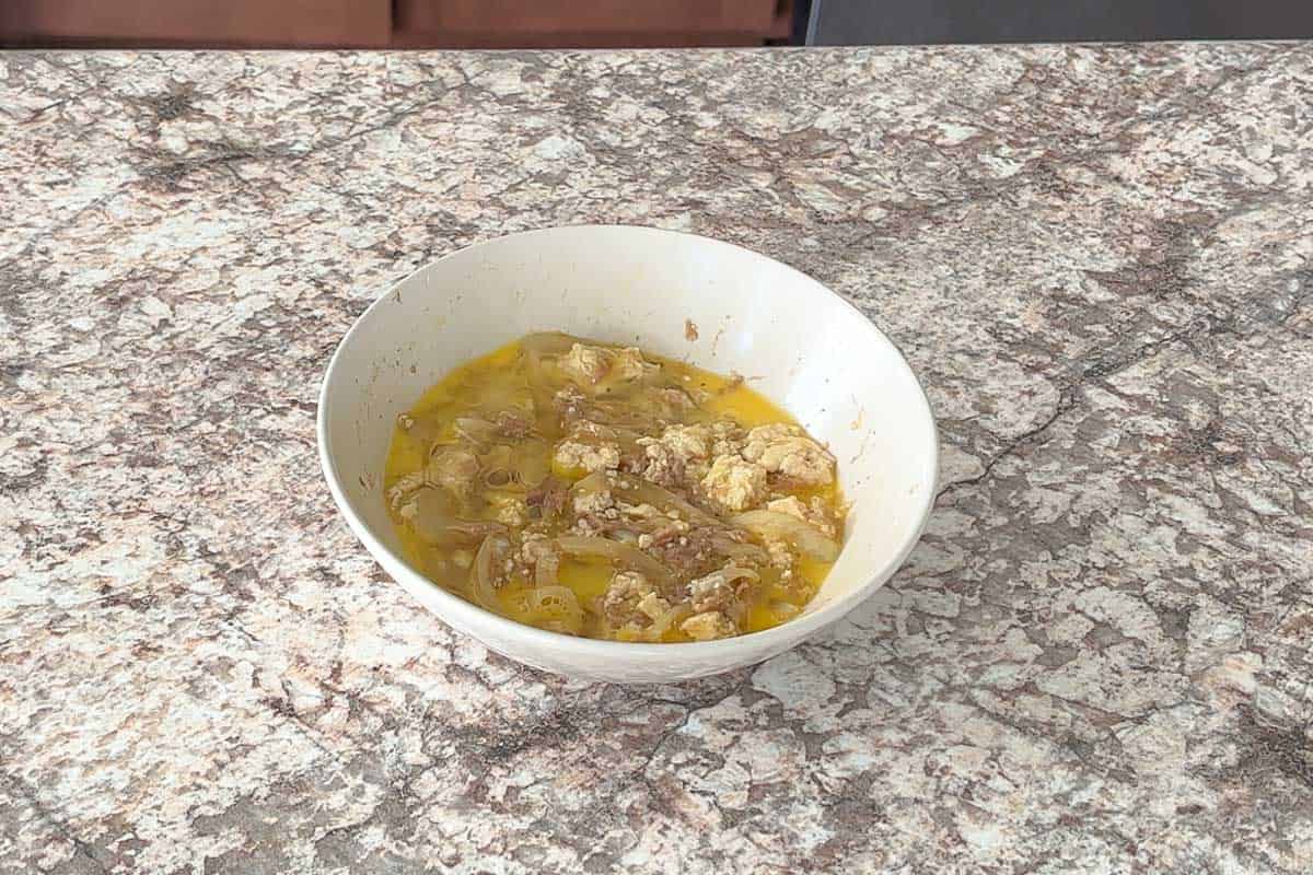 Pout egg on top of onion, tofu, canned tuna mixture.