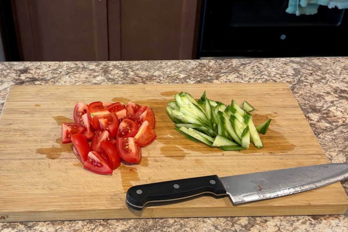 Cut tomatoes into bite-sized pieces and cucumbers into strips.