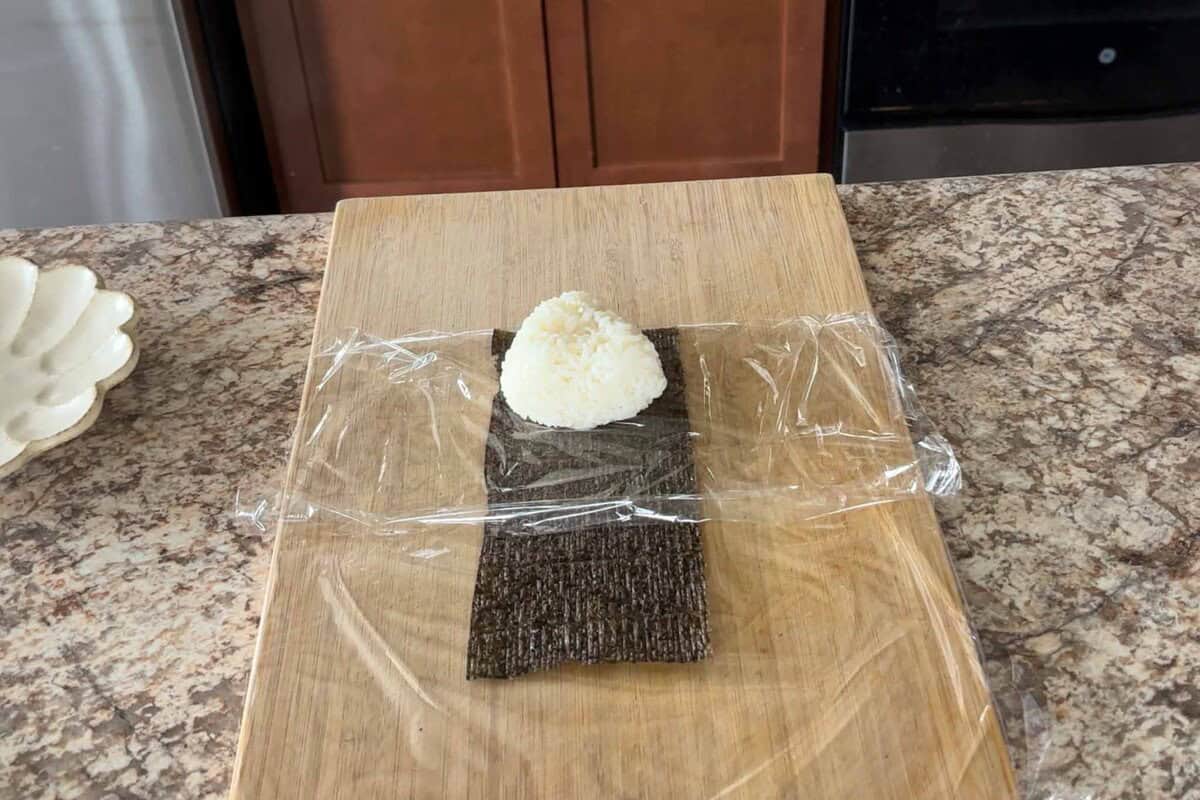 Place onigiri on the plastic wrap.