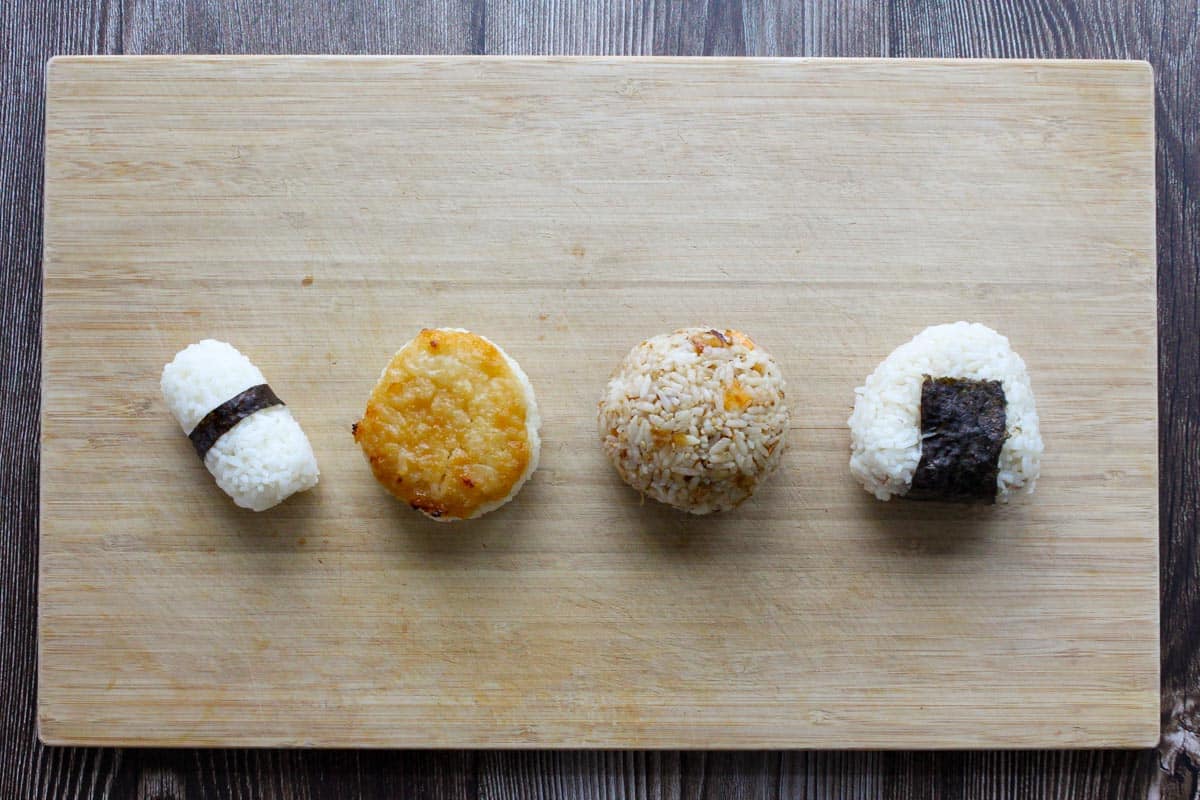 Four onigiri on a cutting board.