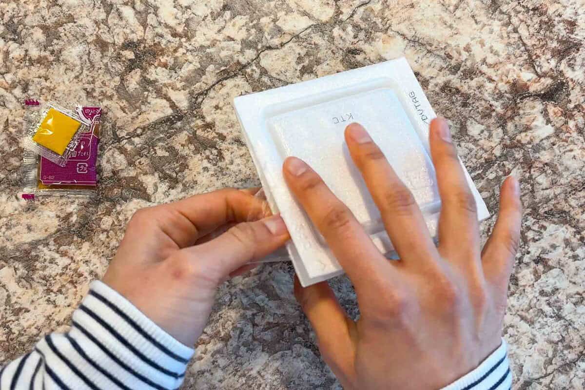 Lift the film and press it against the bottom part of the container and the lid.