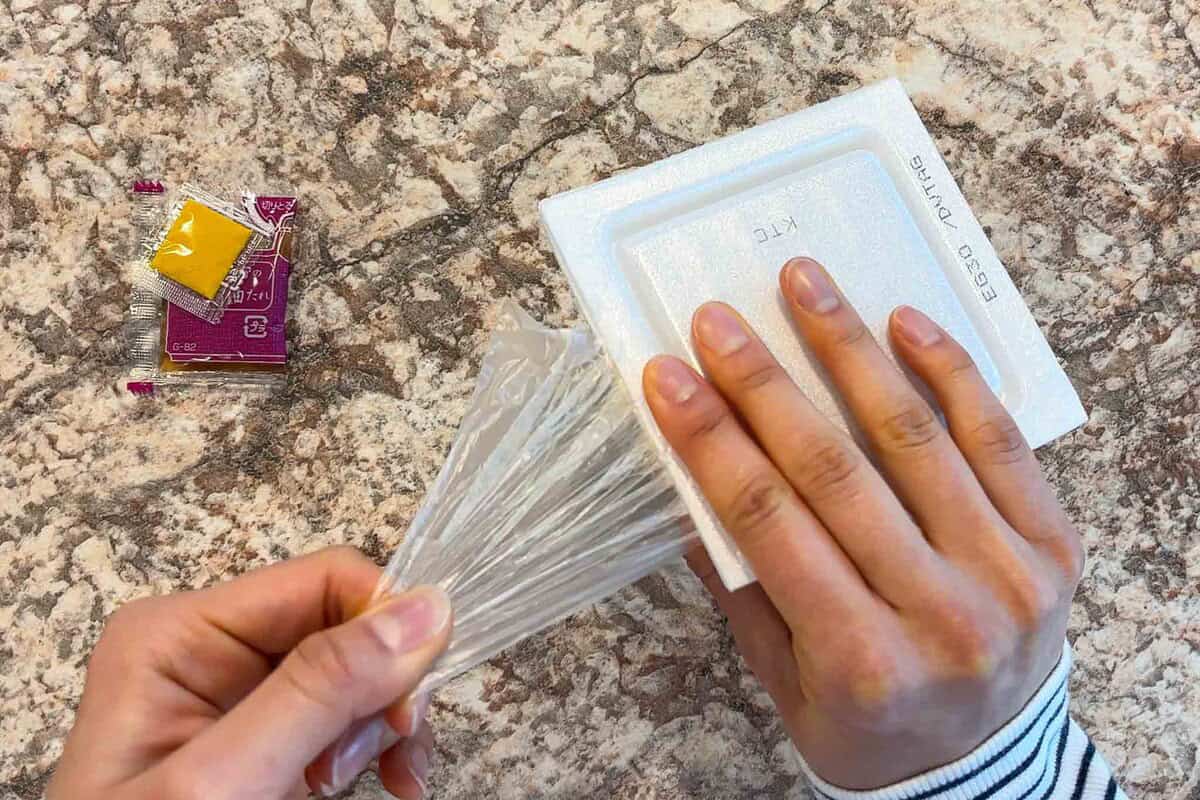 Slide the film along the edge of the container.