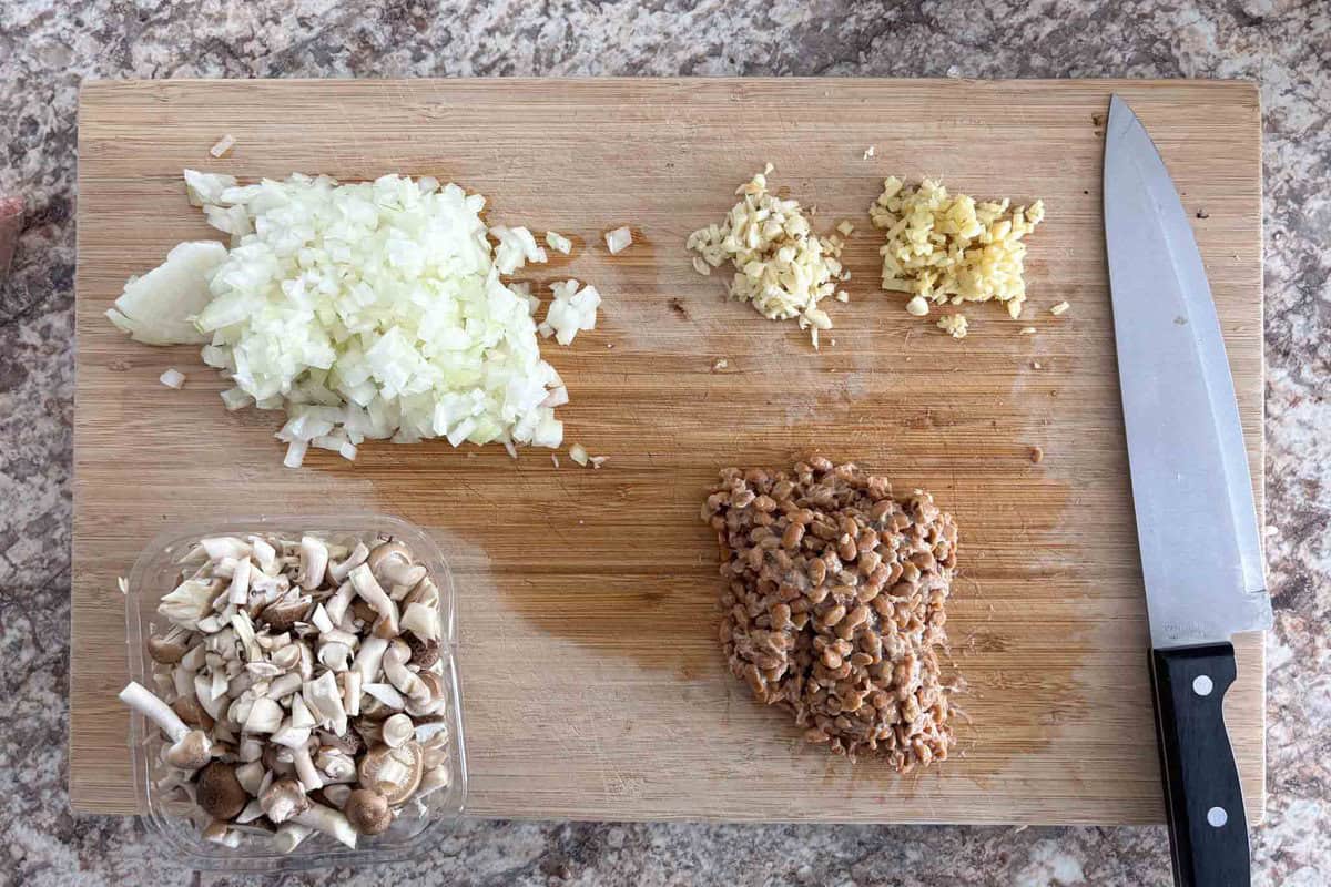 Mince the onion, shimeji mushrooms, garlic, ginger, and natto.